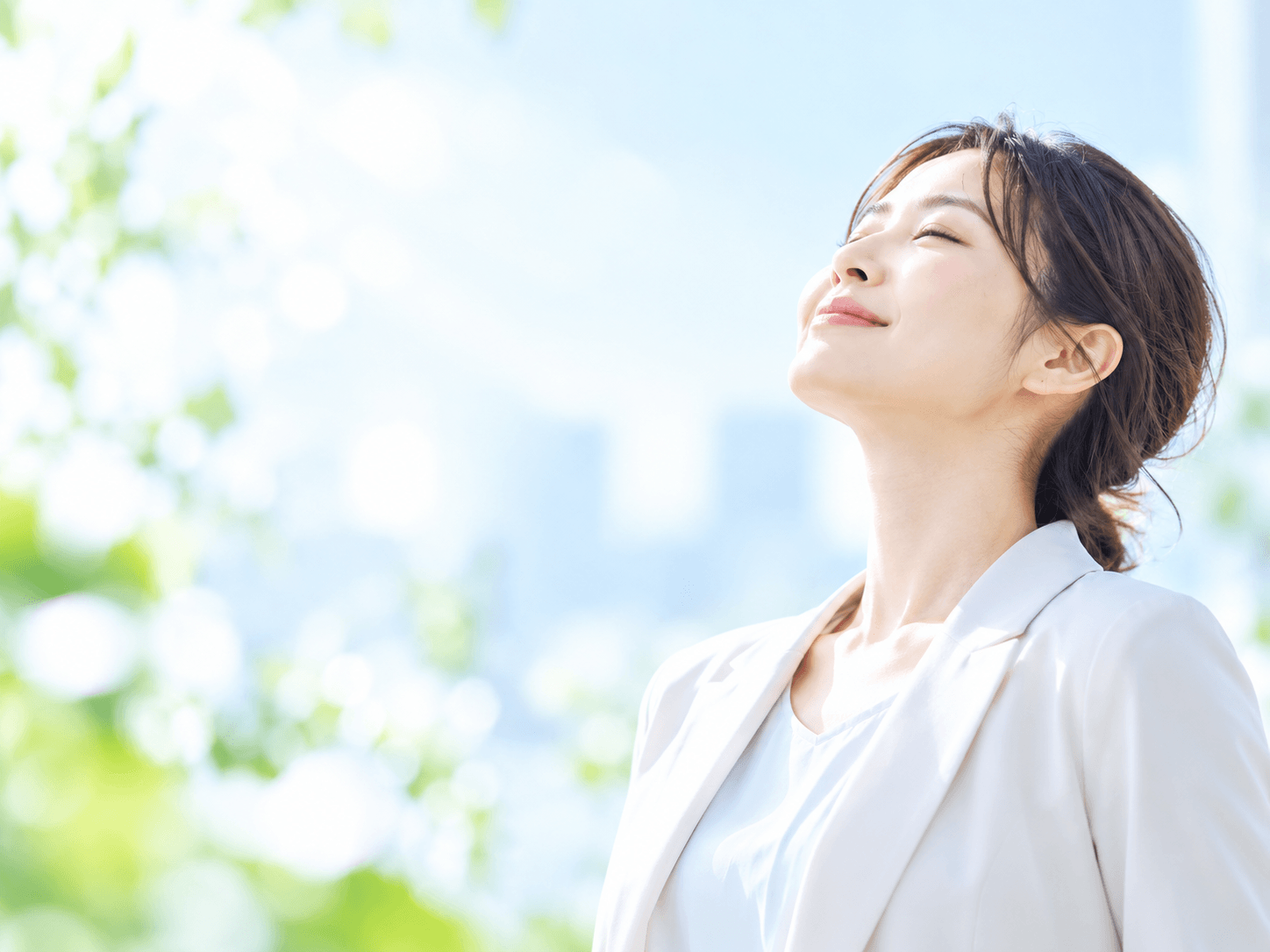 明るい陽光の中で穏やかな表情を見せる女性